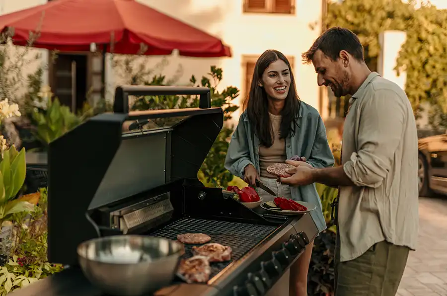 Paar grillt auf ihrer Terrasse.
