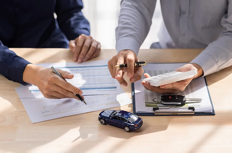 Symbolbild Auto-Leasing: Zwei Personen beraten über Vertragsunterlagen.