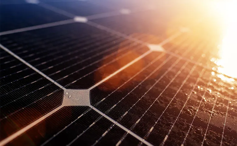 Eine Nahaufnahme einer Solarpanel-Oberfläche, die das Sonnenlicht reflektiert.