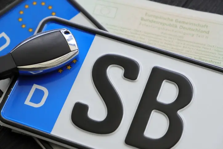 Ein Nummernschild und ein Autoschlüssel.