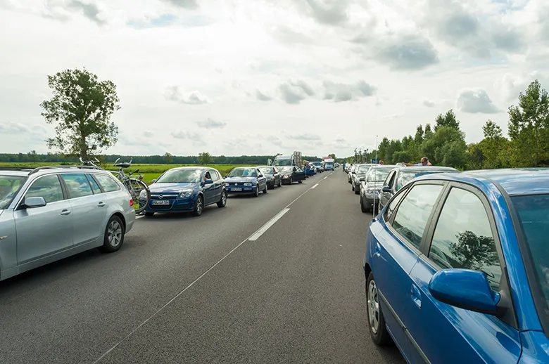 Autos auf einer zweispurigen Straße, die eine Rettungsgasse bilden, um Platz für Einsatzfahrzeuge zu schaffen